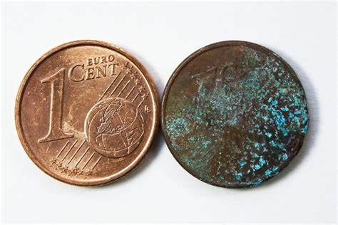 Comparison of a fresh 1 Euro cent coin against a heavily corroded, discoloured coin of the same denomination
